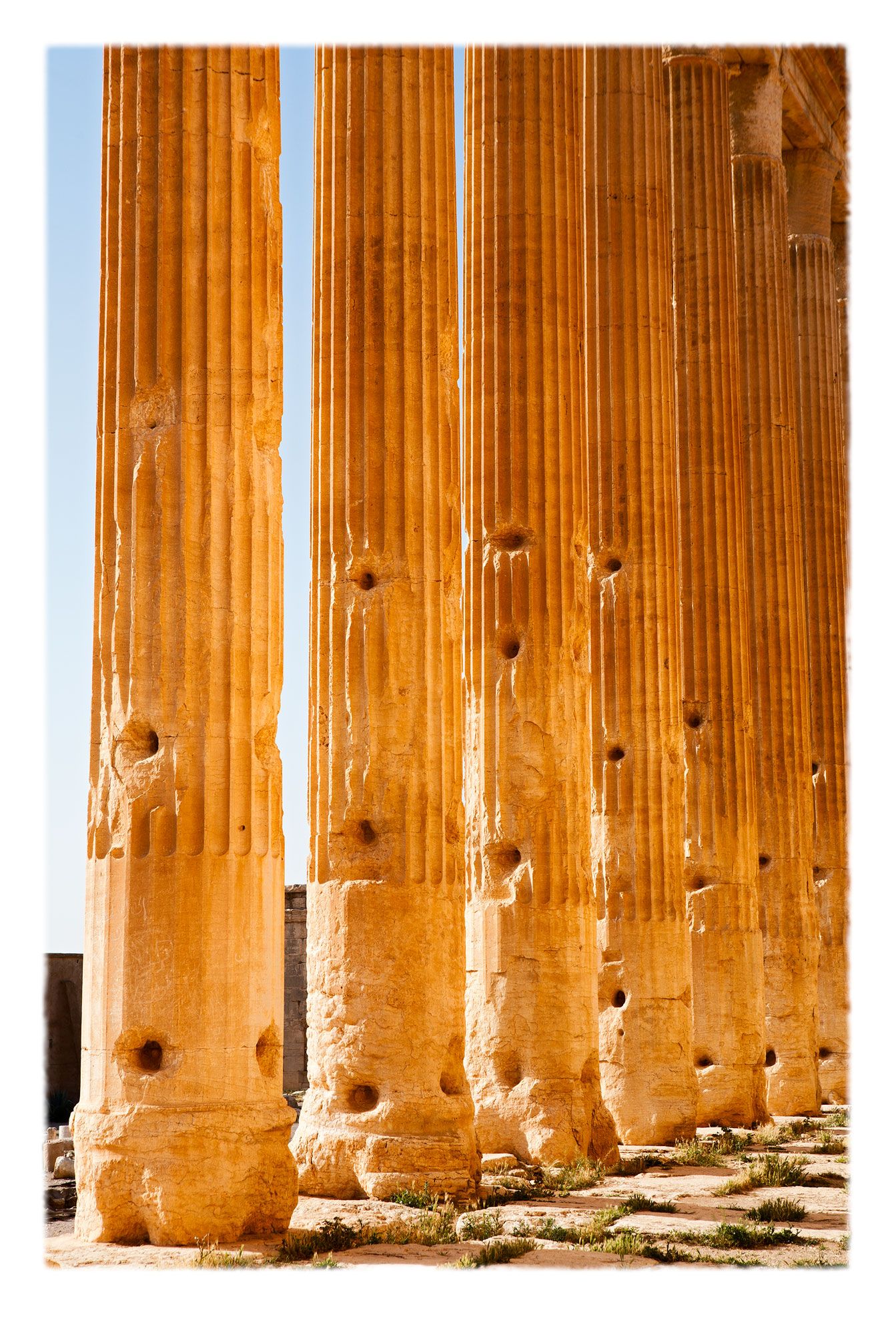 The colonnaded portico, or peristasis behind the cella of the Temple of Baal, destroyed by Daesh in August 2015. The holes were drilled in the 20th-century to accomodate poles which supported lean-to roofs for people's shelter until the state evicted citizenry from the ruins and began restoration.