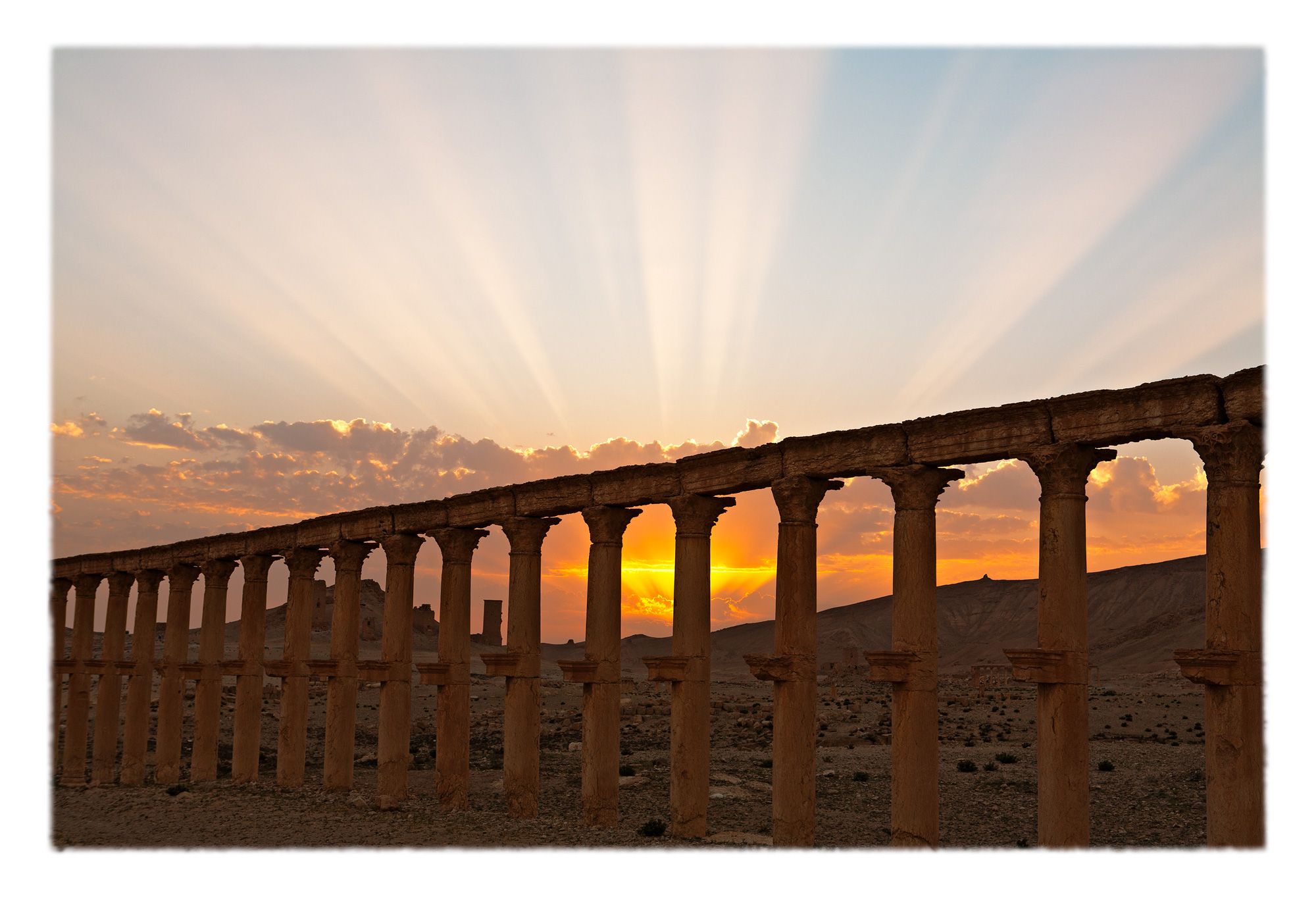 Corinthian colonnade with the peculiarly Palmyran projections from the columns which originally held busts of civic notables and patrons in Palmyra, Syria. The large corinthian capitals make the colonnade appear to be an arcade.