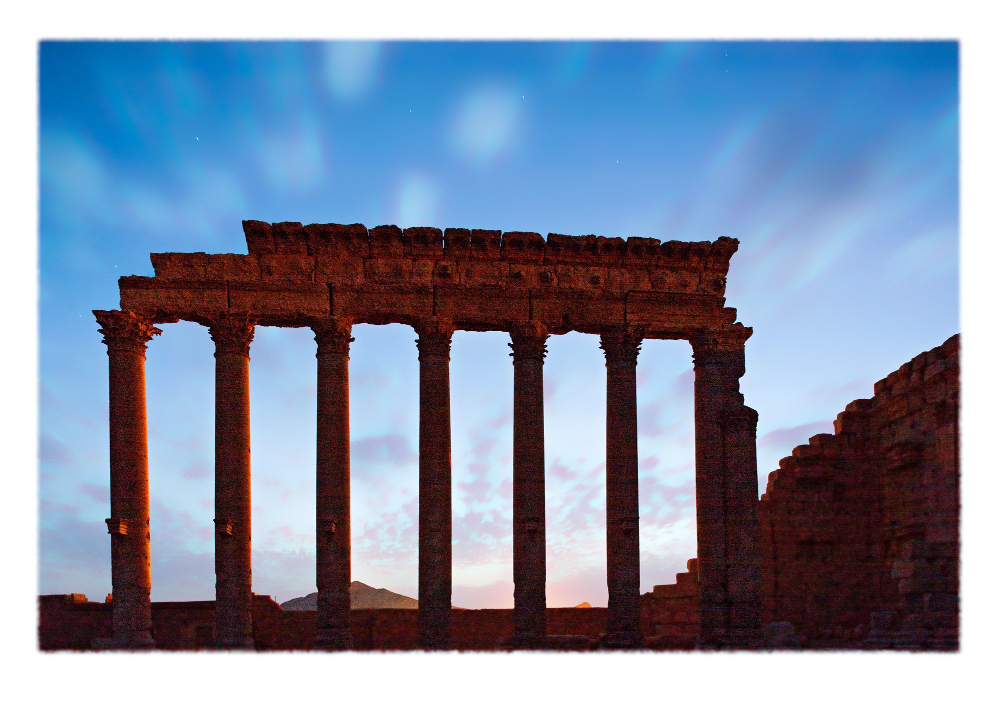 View west through an isolated independent colonnade with eroded entablature. The Baal Temple precinct is elevated on a platform above ground level, a feature that more or less eliminates the natural horizon for people inside and substitutes another artisanal one in its place.