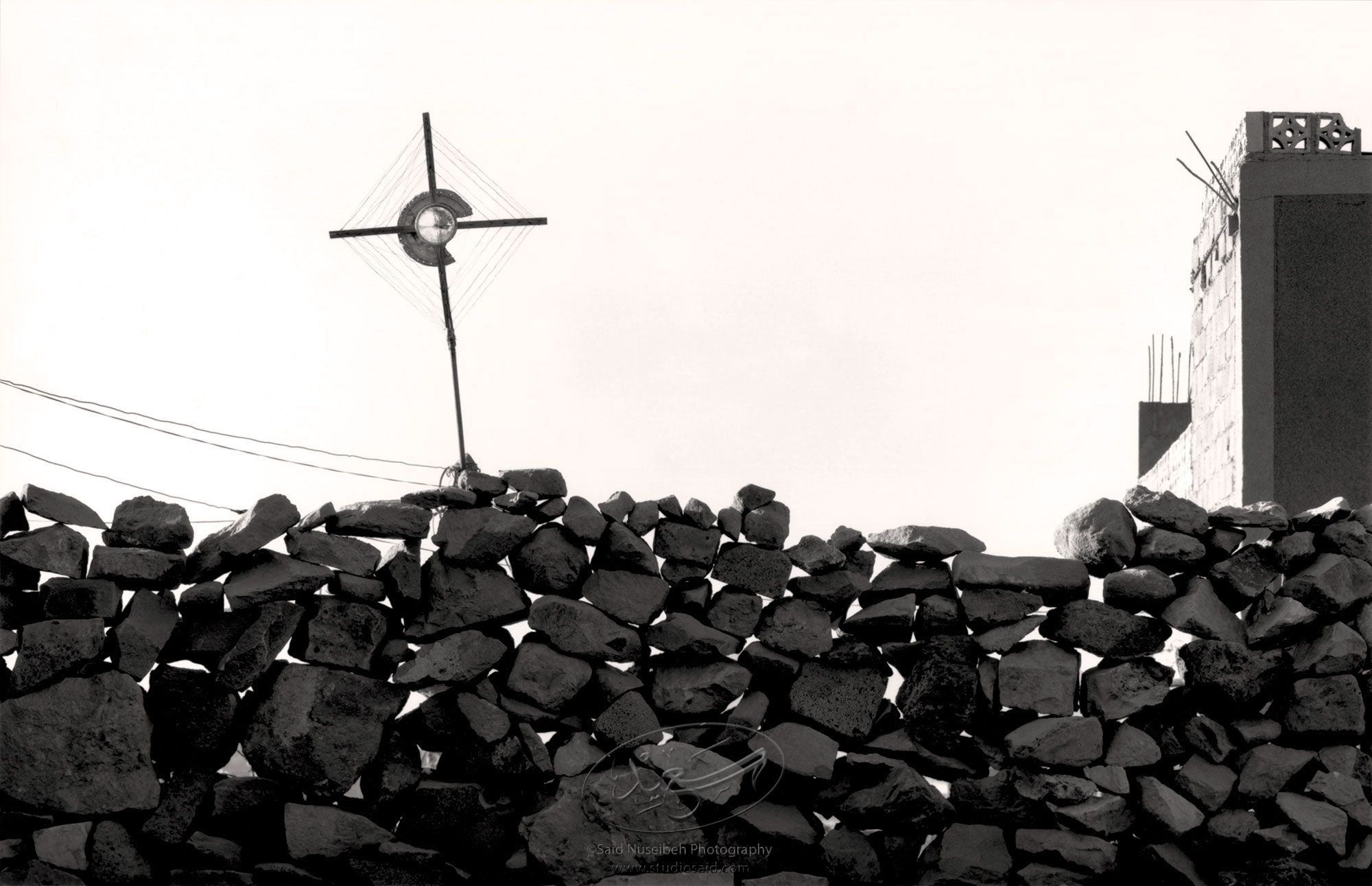 Homemande TV Antenna with hubcap, on perforated rock wall. Sana'a, foothills of Mt. Nuqum