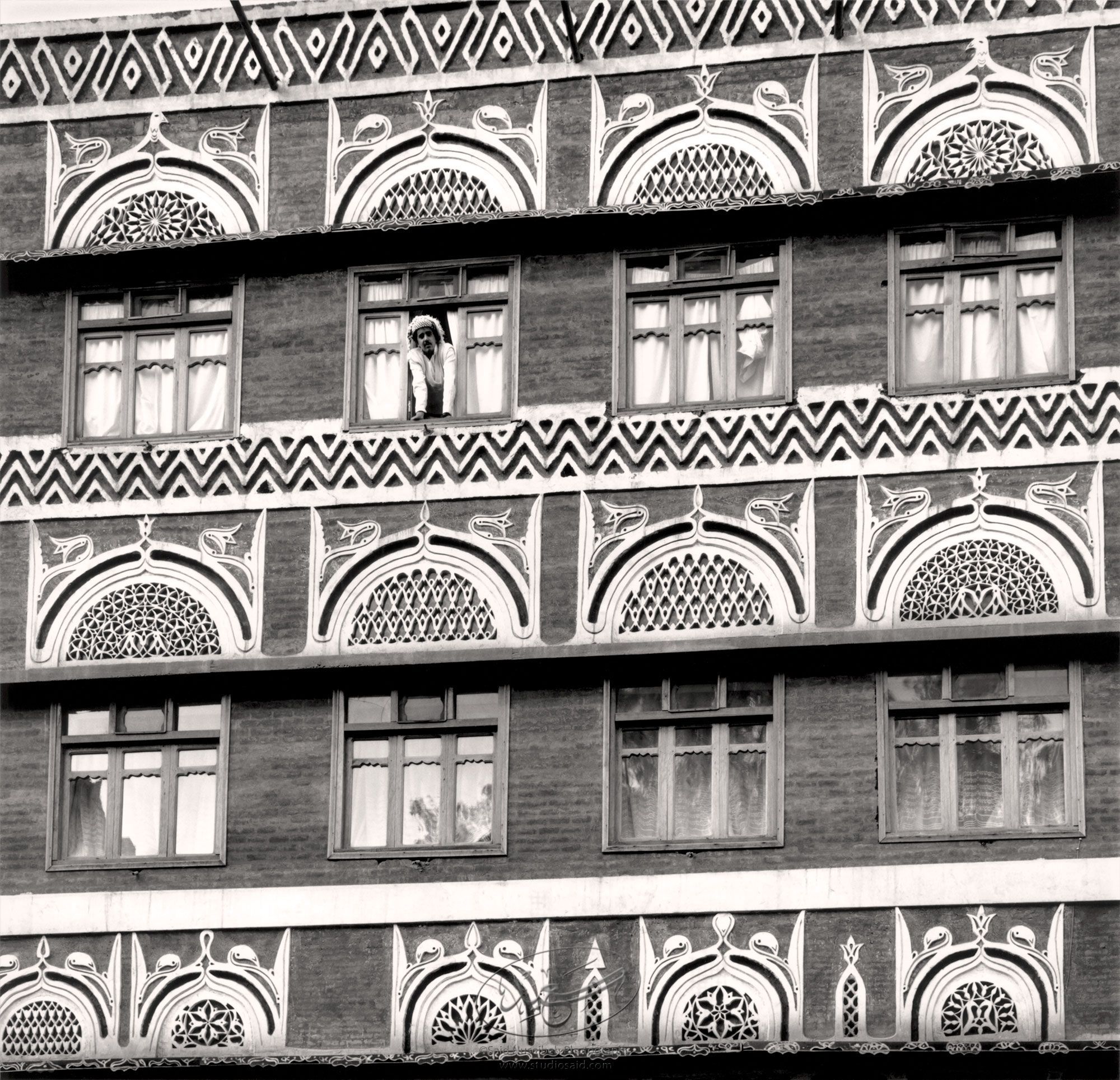 Man pering down from a window. New City, Sana'a