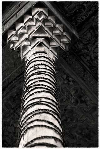 Looking up at a carved wooden capital and column from the Safavid period in Iran